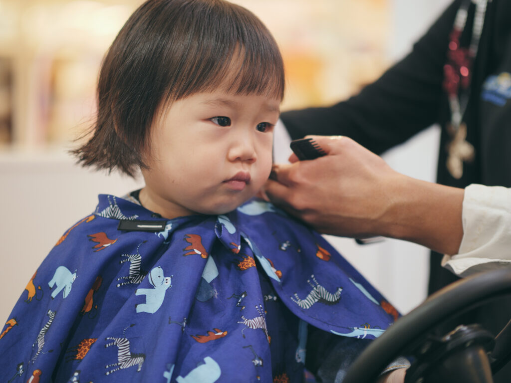 asian baby girl gets hair cut first time Asian toddler getting a haircut at Great Bear Cut kids salon in Pasadena