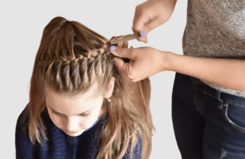 Child with straight hair getting a French braid in the crown area by kids’ stylist at The Great Bear Cut in Pasadena