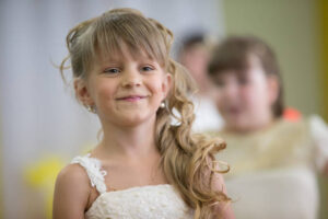 a little girl of six years old does not look at the camera and smiles.