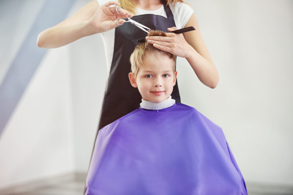 hairdresser's hands making hairstyle to child